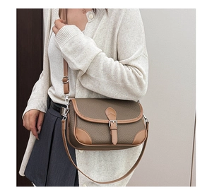 Close-up of vintage brown pebble grain leather square crossbody bag with adjustable strap