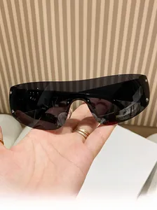 Macro shot of Y2K rimless sunglasses with silver rivets and sleek black lenses