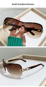 Detail of gold half-frame sunglasses with gradient tea lenses and leopard temple chains