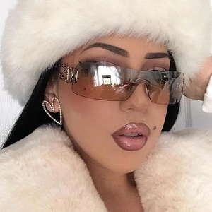 Detail of square rimless sunglasses with gold metal logo and heart diamond earrings