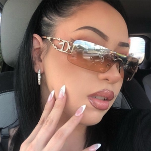 Close-up of golden metal temples with diamond-encrusted CD logo on frameless sunglasses