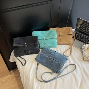 Sacs bandoulière en denim lavé de style japonais en quatre couleurs sur un lit