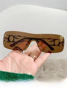 Detail of Y2K rimless sunglasses featuring hollow metal flame temples and amber lenses