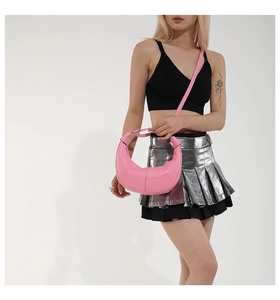 Detail of pink half-moon shoulder bag with smooth faux leather and curved stitching detail