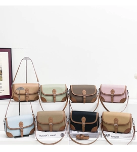 Row of colorful vintage saddle bags in pebble leather with contrast piping detail