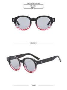 Detail einer ovalen Retro-Sonnenbrille mit schwarz-rotem Rahmen und grauen Gläsern