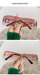 Detail of gold metal Y2K rimless sunglasses with gradient pink lenses and flame accents