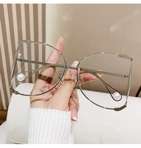 Close-up of oversized silver D-frame sunglasses with elegant white pearl accents