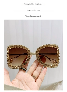 Close-up of D-frame sunglasses with amber rhinestones and brown gradient lenses