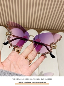 Detail of purple gradient butterfly sunglasses with rhinestone trim on rimless lenses