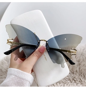 Détail de lunettes de soleil papillon sans monture avec ornements dorés et perles