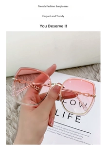 Detail of pink gradient lenses and golden metal chain link design on stylish sunglasses