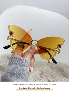 Detailed close-up of amber butterfly frameless sunglasses with colorful rhinestones decor