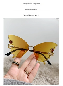 Close-up of butterfly rimless sunglasses with orange gradient lenses and rhinestones