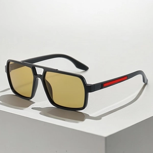 Detail view of square pilot sunglasses with black frame and red stripe on the temple