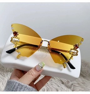 Detail of yellow butterfly rimless sunglasses with rhinestones and branded case