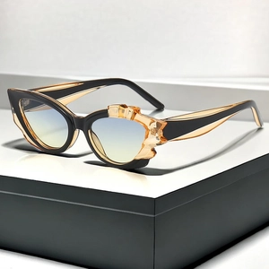 Details einer Cat-Eye-Sonnenbrille mit skulpturalem Rahmen und bernsteinfarbenem Harz