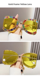 Close-up of golden D-frame sunglasses with colorful crystals and yellow lenses