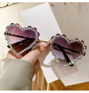 Détail de lunettes de soleil cœur avec verres dégradés violets et strass AB