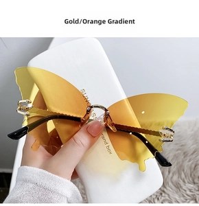 Détail de lunettes de soleil papillon sans monture avec verres dégradés orange et branches or