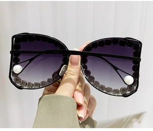 Detail of D-frame sunglasses with purple gradient lenses, rhinestones, and pearls