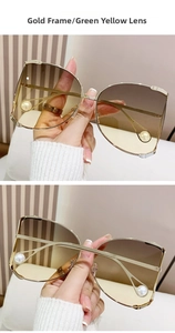 Detail of oversized gold metal sunglasses featuring gradient lenses and pearl accents
