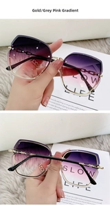 Detail of oversized gold butterfly sunglasses with chain temples and gradient lenses