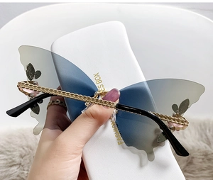 Detail of butterfly rimless sunglasses with gradient lenses and golden chain temples