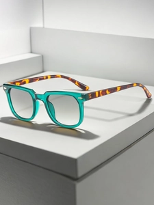 Detail of square vintage sunglasses with translucent teal frames and amber tortoise temples