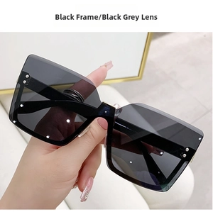 Detail of square rimless sunglasses with black grey lenses and silver stud rivets