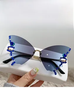 Detailed close-up of butterfly wing shaped rimless sunglasses with blue rhinestones