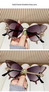 Detail of butterfly sunglasses with gold frame, gradient grey lenses and rhinestone edges