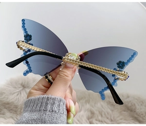 Close-up of butterfly rimless sunglasses with blue crystals and gradient lenses