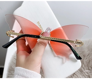 Détail de lunettes papillon sans monture avec verres dégradés et branches dorées