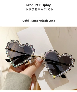 Détail de lunettes de soleil cœur à monture dorée avec strass colorés et verres foncés