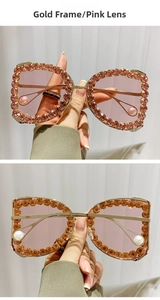 Detail of gold frame sunglasses with pink rhinestones and pearl temple tips