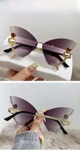 Detail of rimless butterfly sunglasses with gradient grey lenses and rhinestone accents