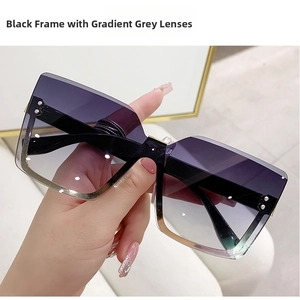 Close-up of oversized square sunglasses with black frames and grey gradient lenses