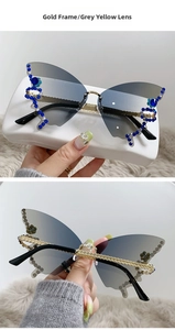 Detail of butterfly rimless sunglasses showing gold metal stems and blue floral rhinestones