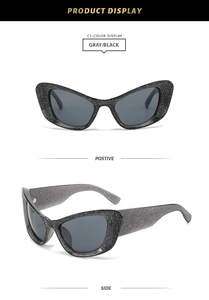 Detailed close-up of dark grey cat-eye sunglasses featuring sparkling silver glitter frame