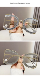 Close-up of gold metal frame sunglasses with crystal rhinestones and pearl details