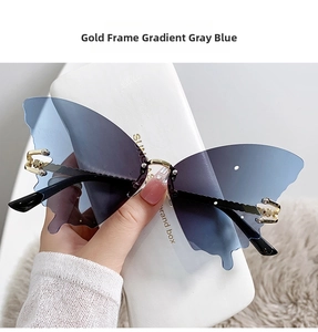Détail de lunettes de soleil papillon sans monture dorée avec verres dégradés gris bleu