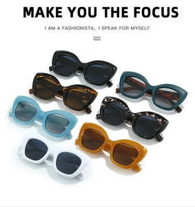 Close-up of stylish thick frame cat eye sunglasses in various retro colors on white