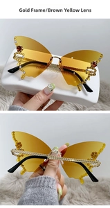 Detail of butterfly shaped rimless sunglasses with rhinestones and gold chain temples