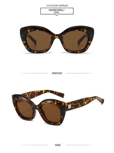 Close-up of tortoise shell cat-eye sunglasses with gold metal hinges and tea lenses