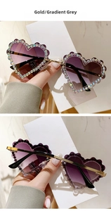 Détail de lunettes de soleil coeur sans monture avec strass colorés et branches en métal doré