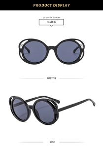 Détail de lunettes de soleil rondes noires avec monture large et détails ajourés à trois trous