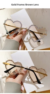 Détail de lunettes de soleil coeur sans monture avec cadre doré et strass étincelants