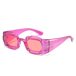 Occhiali da sole quadrati rosa traslucidi con design delle aste a onda su bianco