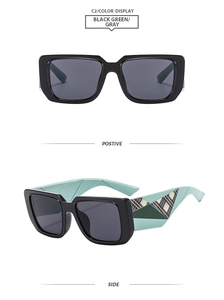 Detail view of square black sunglasses with unique green geometric pattern temples